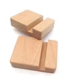 Natural beech wood mobile phone stand with coin slot and custom name engraving on a desk