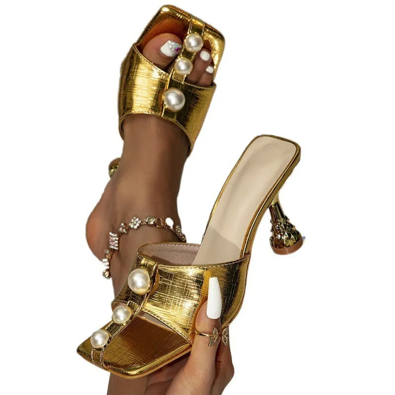 Gold electroplated square toe high heel sandals with fish mouth design on a surface