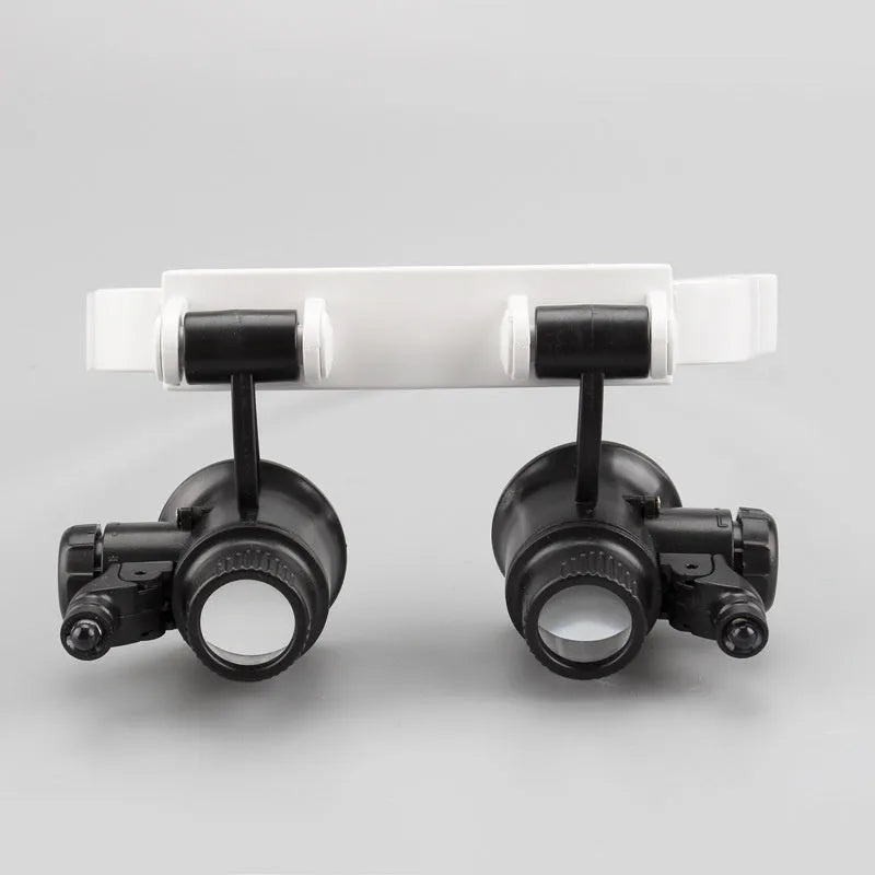 White head-mounted magnifying glass with LED light, shown folded and unfolded.
