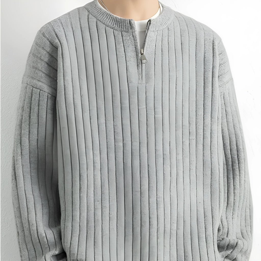 Man wearing a grey half-zip loose fit knitted sweater pullover.