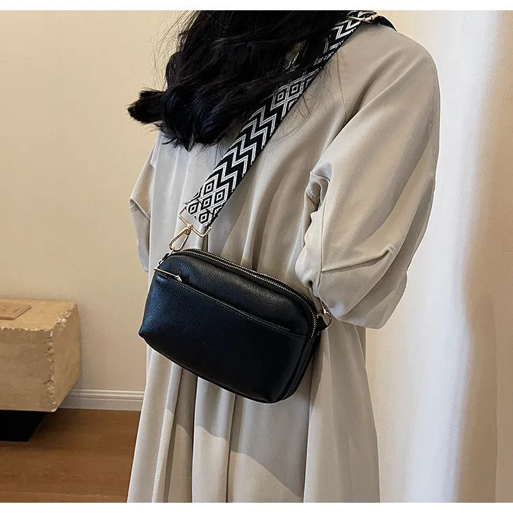 Women's cross-body bag in black, urban simplicity style, with visible sewing thread and sandwich pocket on front.