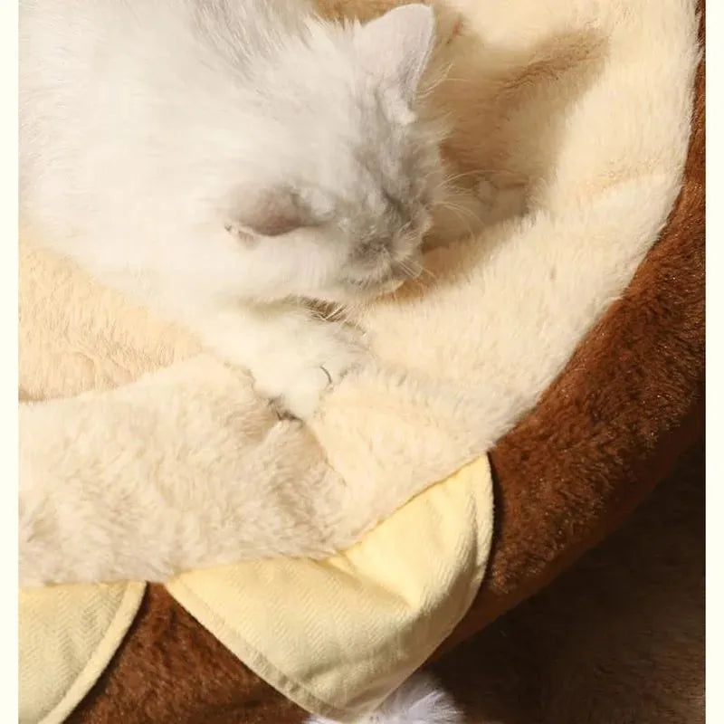 A round grey pet bed for cats and dogs on a wooden floor.