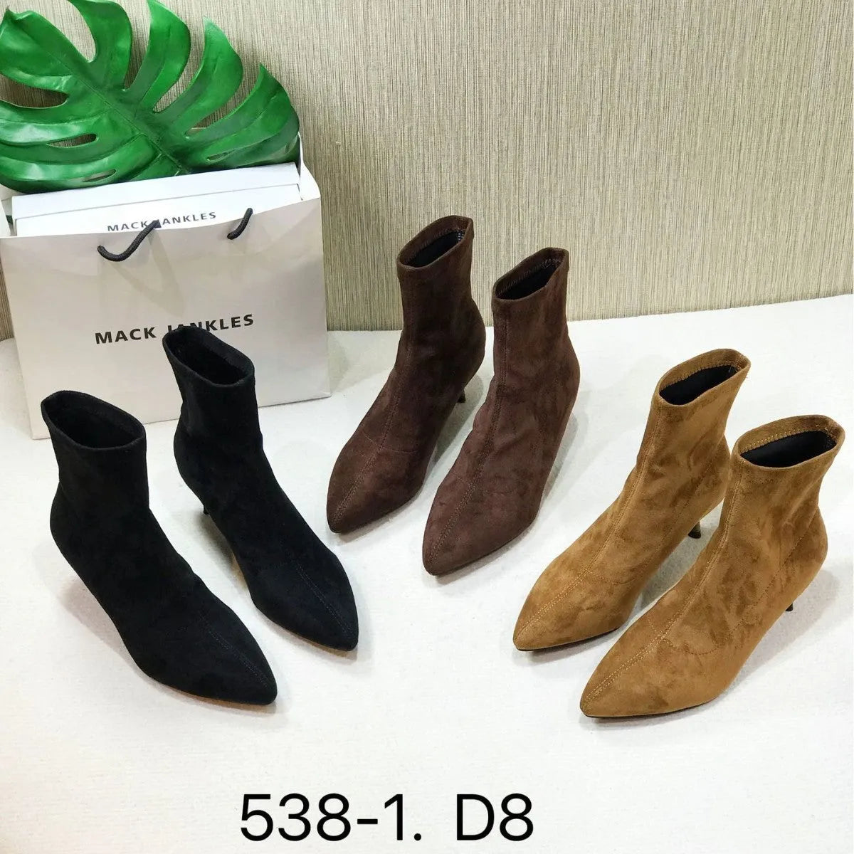 Black pointed toe women's ankle boot with a stiletto heel on a plain background.