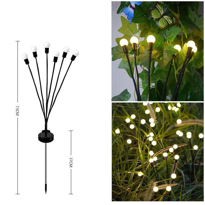 Solar-powered LED garden ground light with stainless steel spike, lit up in a lawn at dusk.