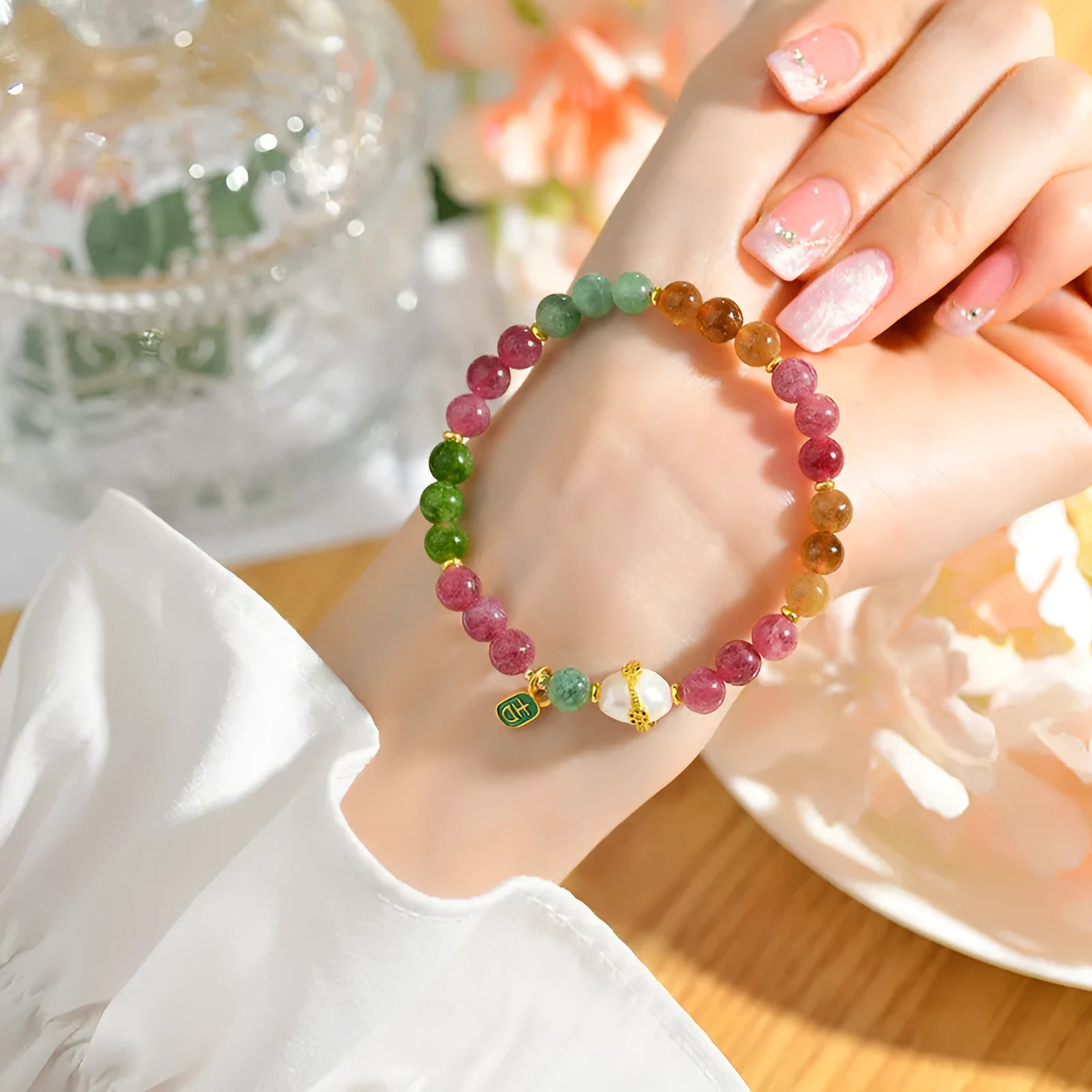 Close-up of a chalcedony bracelet with geometric 6.5mm beads in a tourmaline colour on a wrist.