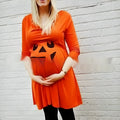 Orange maternity dress on a hanger, suitable for Halloween and seasonal wear.