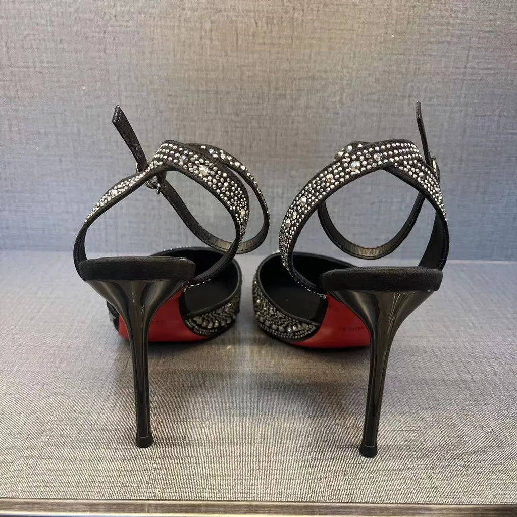Women's black stiletto high heel with pointed toe and red sole, shown from the side.