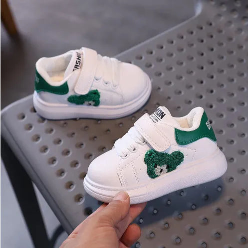 Children's black sports shoes with a cartoon bear design on the artificial leather upper and a rubber sole.