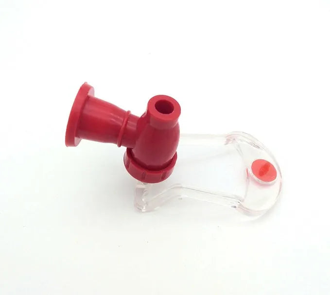 Red Magic Tap plastic soda dispenser attached to an inverted 2-litre bottle on a table.