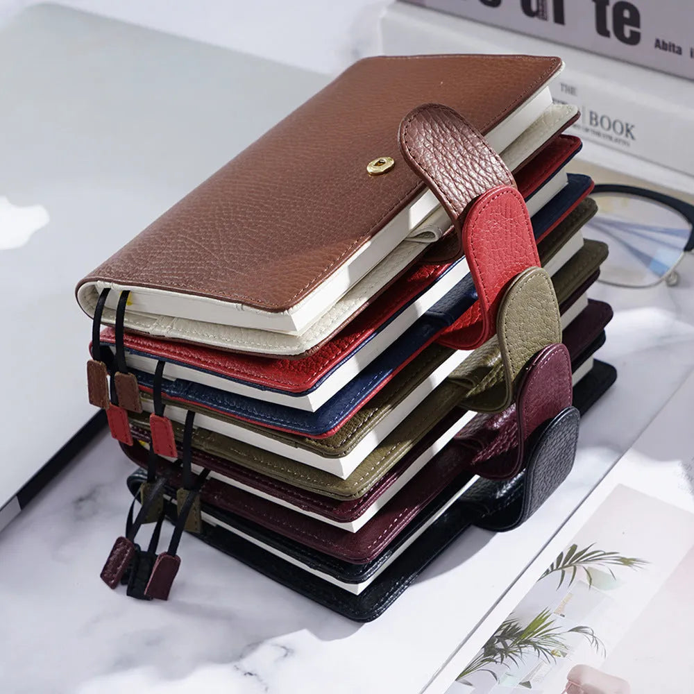 A6 leather notebook with lychee pattern cowhide cover showing loose-leaf binding in three colour options