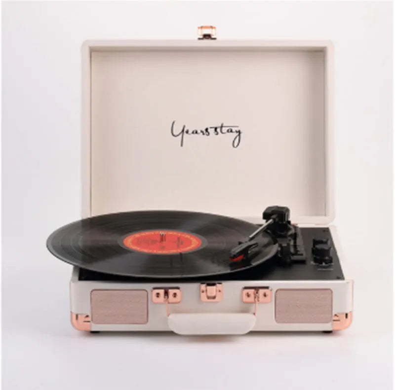 Portable Bluetooth record player in a leather-textured suitcase case, shown in a selection of colours.
