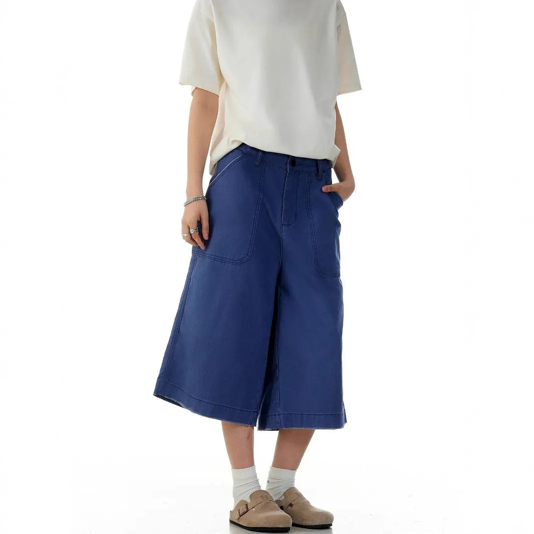 Men's French blue cotton shorts, loose straight-leg fit, mid-rise waist with zipper fly, lying flat.