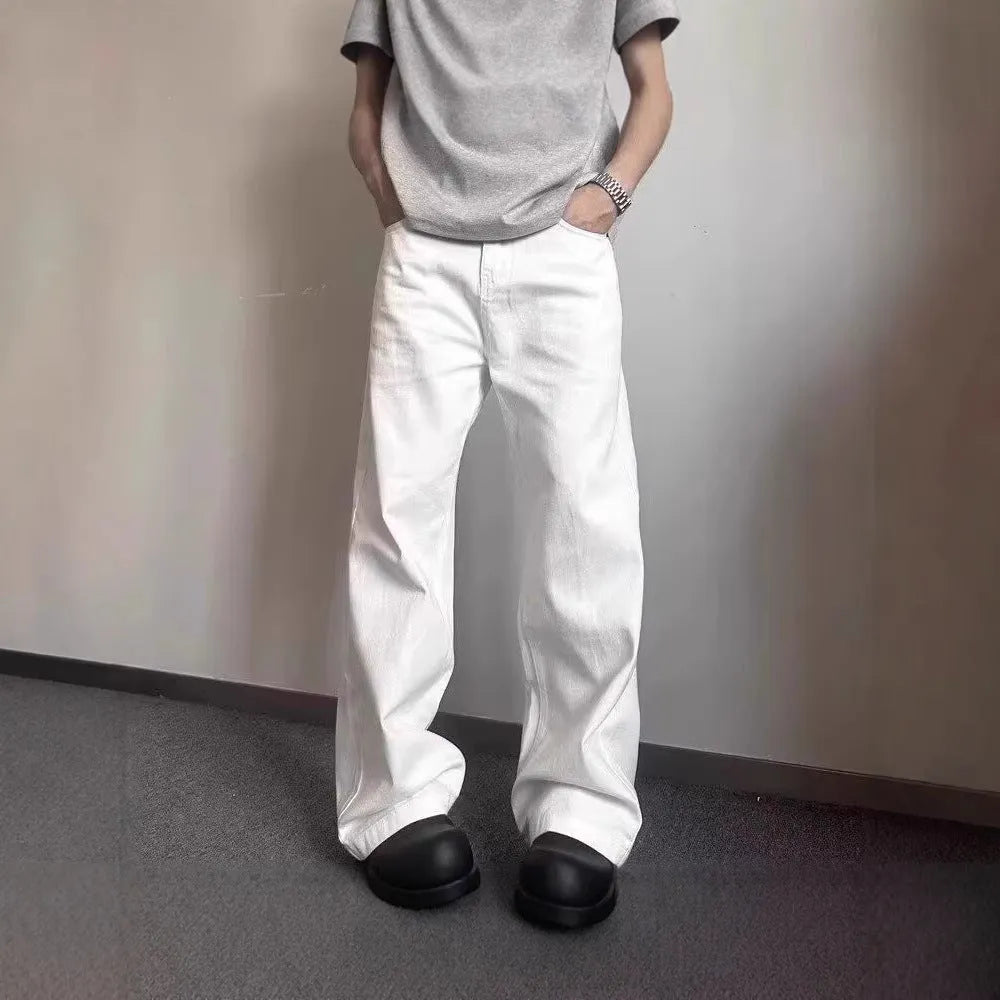 A pair of men's loose-fit white straight-leg cotton jeans on a plain background.