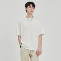 A man's loose-fit drape knit T-shirt in a solid colour, shown in brown, white, and black options.