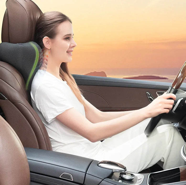 Dark grey memory foam car neck pillow resting on a car seat headrest.