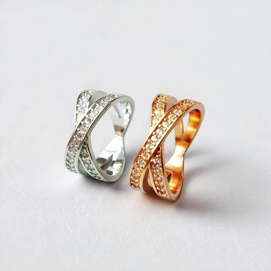 Silver and rose gold metal cross ring with micro-inlaid zircon stones on a simple band.