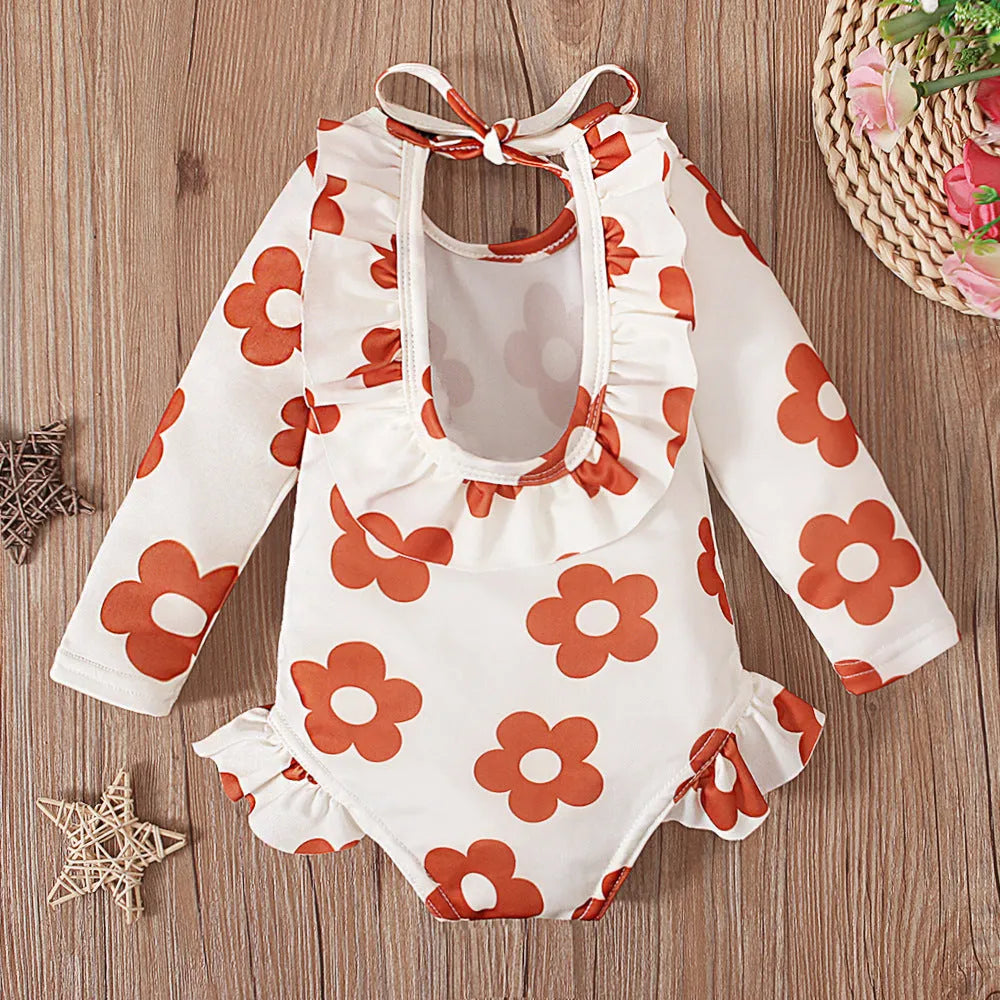 Girl's floral print open back swimsuit in orange, showing crew neck and briefs style.