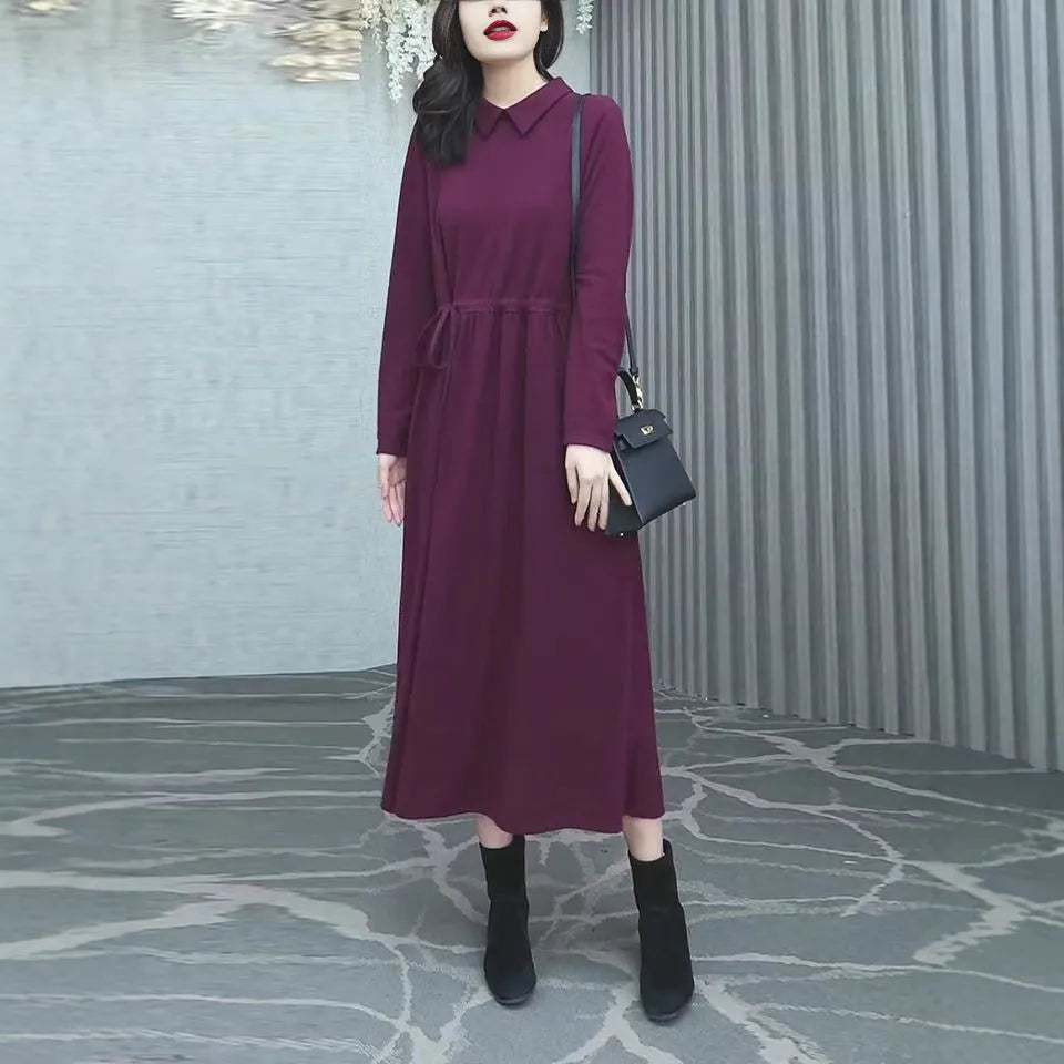A purplish-red plus size winter dress with long sleeves and a long, flowing skirt, laid flat.