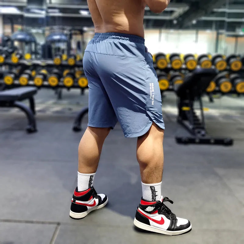 Men's thin quick-drying running shorts in black, blue, or grey on a hanger.