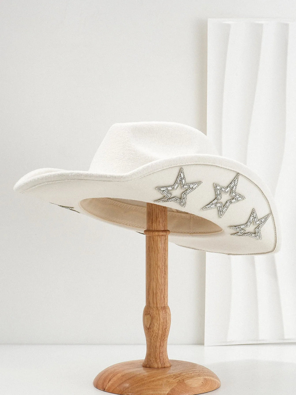 Beige woolen felt western denim top hat with a conical crown and a hexagonal star decoration on the front.