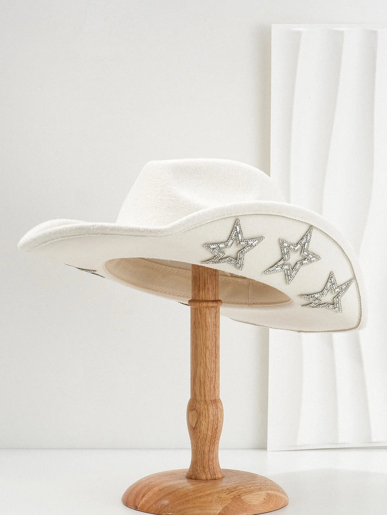Beige woolen felt western denim top hat with a conical crown and a hexagonal star decoration on the front.