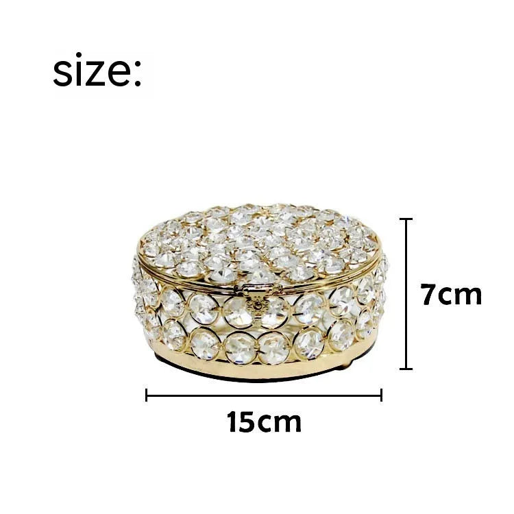 Transparent crystal glass jewelry storage box with a French gold-coloured metal frame on a table.