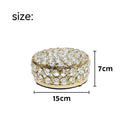 Transparent crystal glass jewelry storage box with a French gold-coloured metal frame on a table.