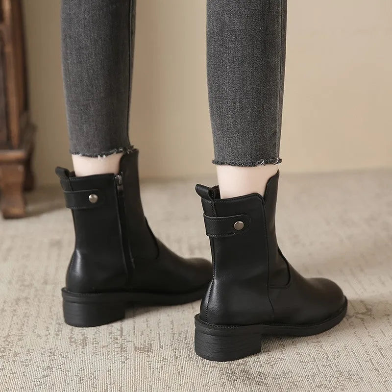 Black women's low heel ankle boots with side zip closure and round toe on a rubber sole.