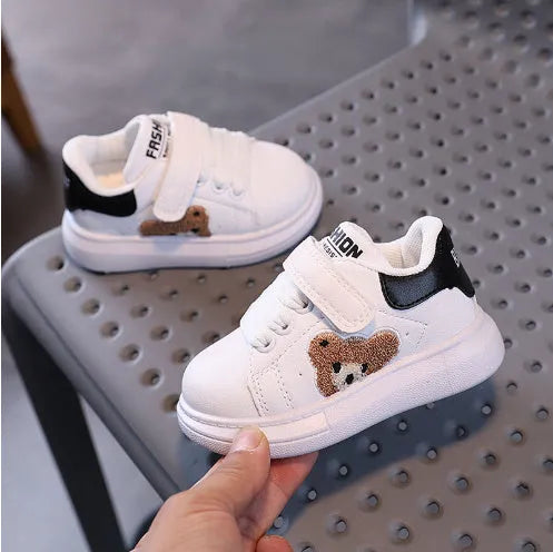 Children's black sports shoes with a cartoon bear design on the artificial leather upper and a rubber sole.