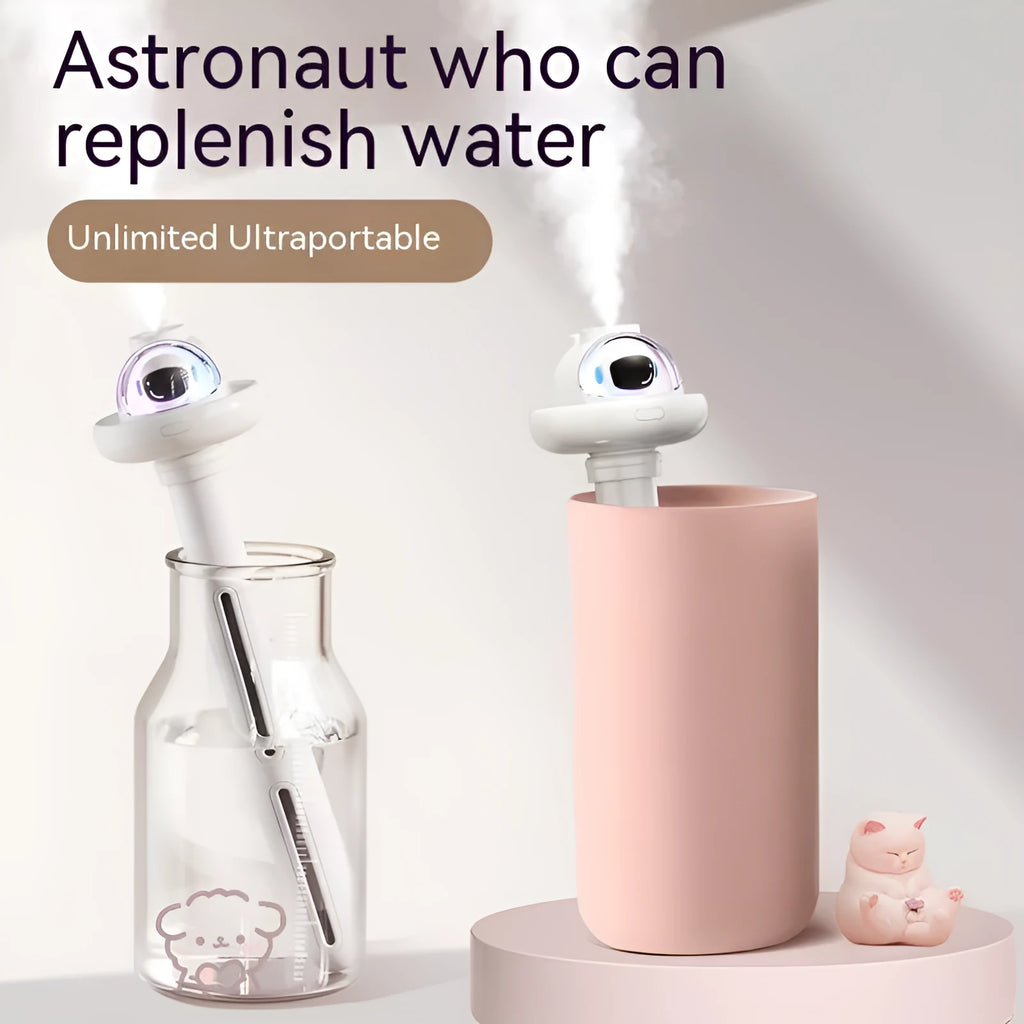 Small white plastic astronaut humidifier with USB cable on desk