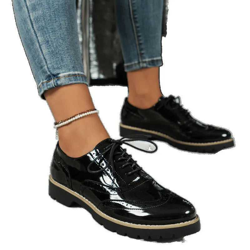 Women's black PU leather lace-up loafers with sequin details and a wedge heel, shown on a foot.