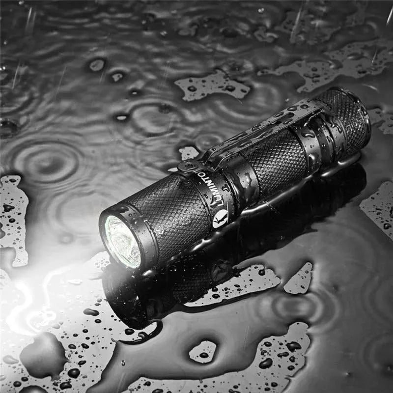 Black Lumintop Tool AA2.0 compact keychain flashlight with magnetic tail cap on a keyring.