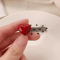 Red heart-shaped hair clip with retro dot patterns and willow leaf clip design