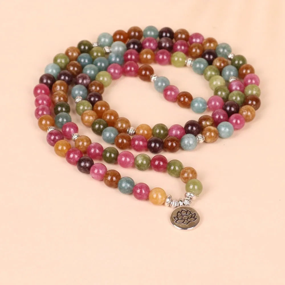 108 bead multi-strand bracelet with natural tourmaline stones and alloy clasp on a wrist.