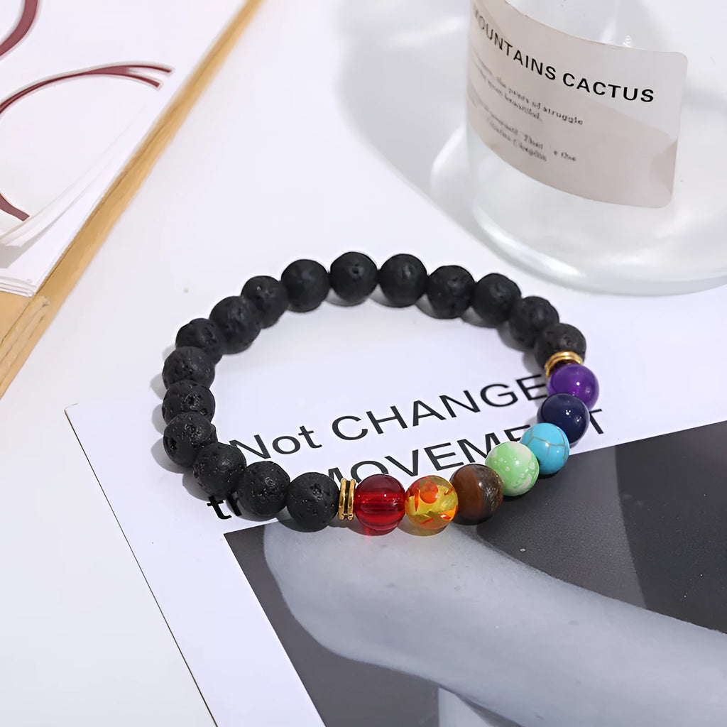 Handmade black lava seven chakra beaded bracelet on neutral background, 8mm or 10mm beads