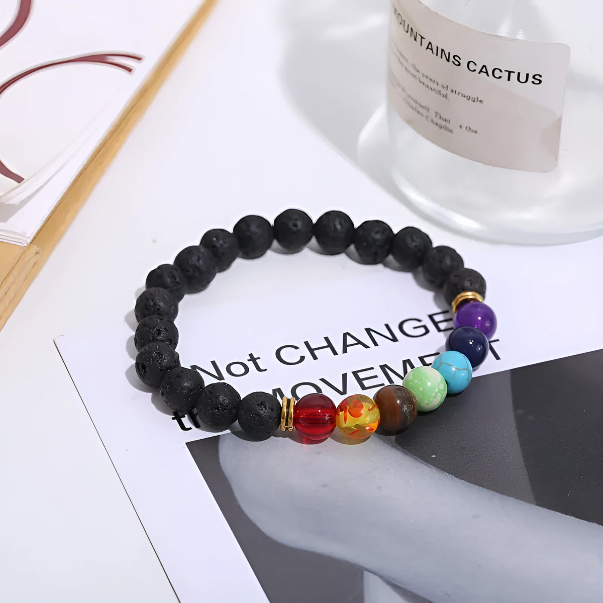 Handmade black lava seven chakra beaded bracelet on neutral background, 8mm or 10mm beads
