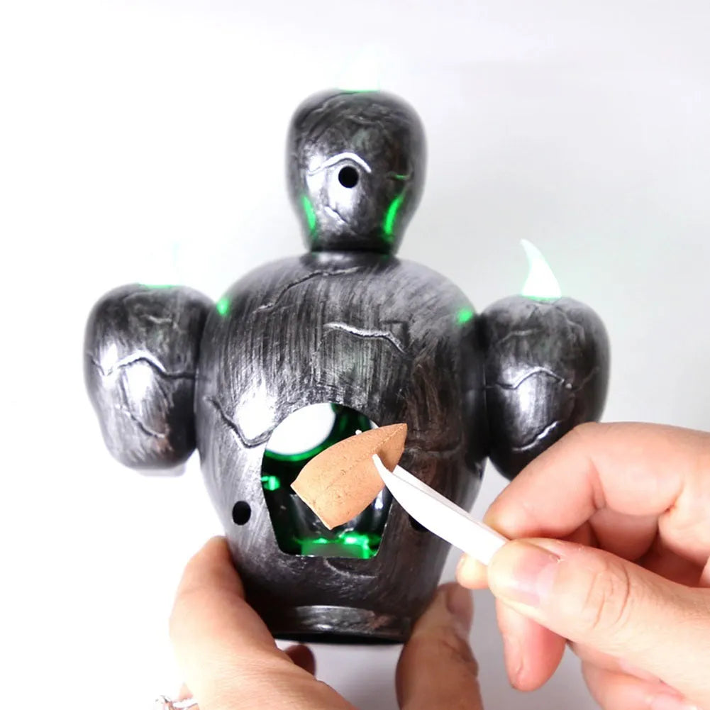 Golden skull ornament with LED light shaped like a skeleton hand holding a candle