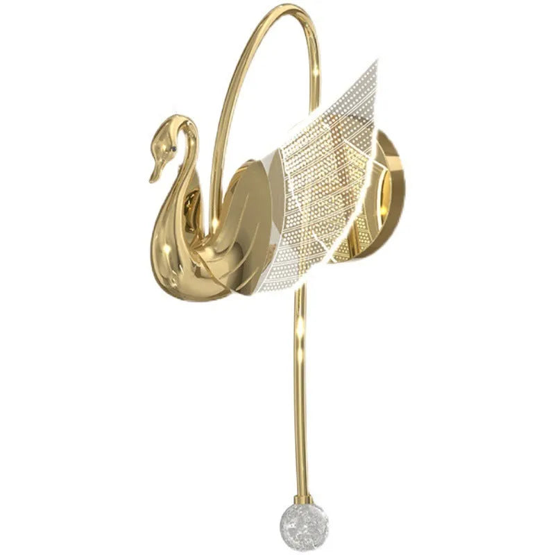 Gold modern swan-shaped wall lamp with acrylic shade mounted beside a bed.