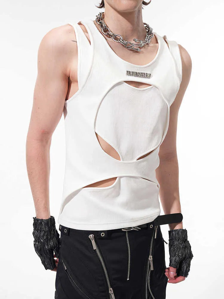 Man wearing a loose-fitting black sleeveless waistcoat with a round neck over a white t-shirt.