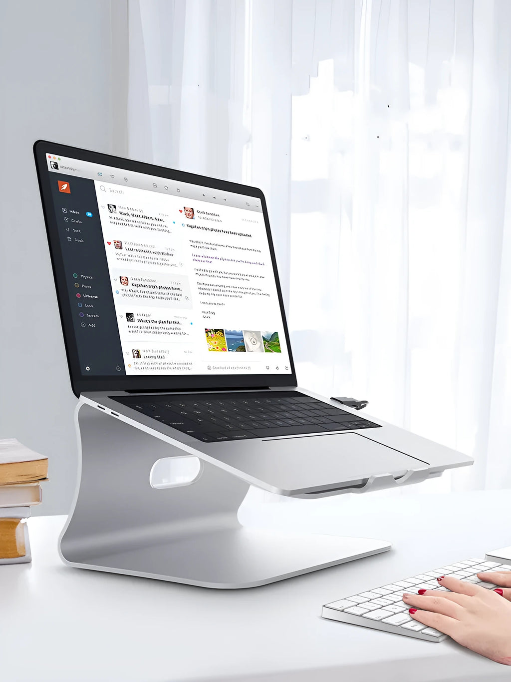 Silver aluminium laptop cooling stand with striped texture and 360-degree rotating base on a wooden desk.