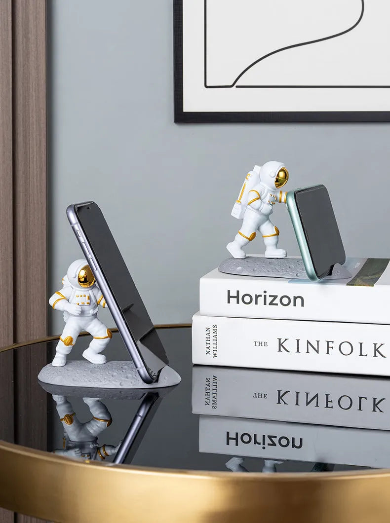 Astronaut decoration spaceman plastic mobile phone holder in blue, gold, and silver colours for lazy binge-watching