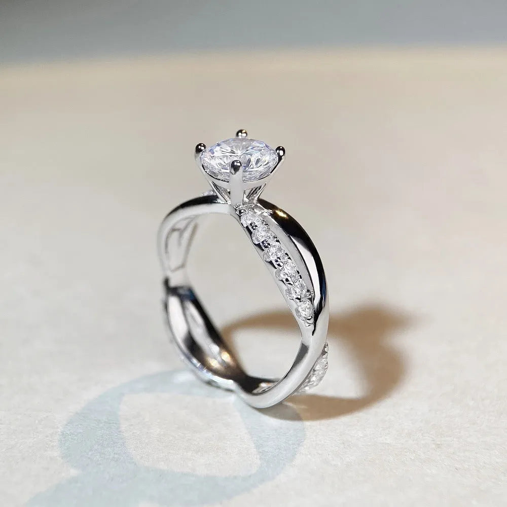 Silver ring with twisted geometric band and a 1 karat moissanite in a four-claw setting.