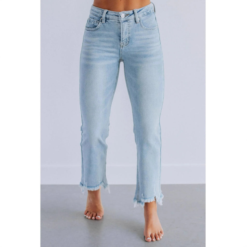 Women's solid colour denim jeans with hand-worn distressing in dark blue, laid flat.