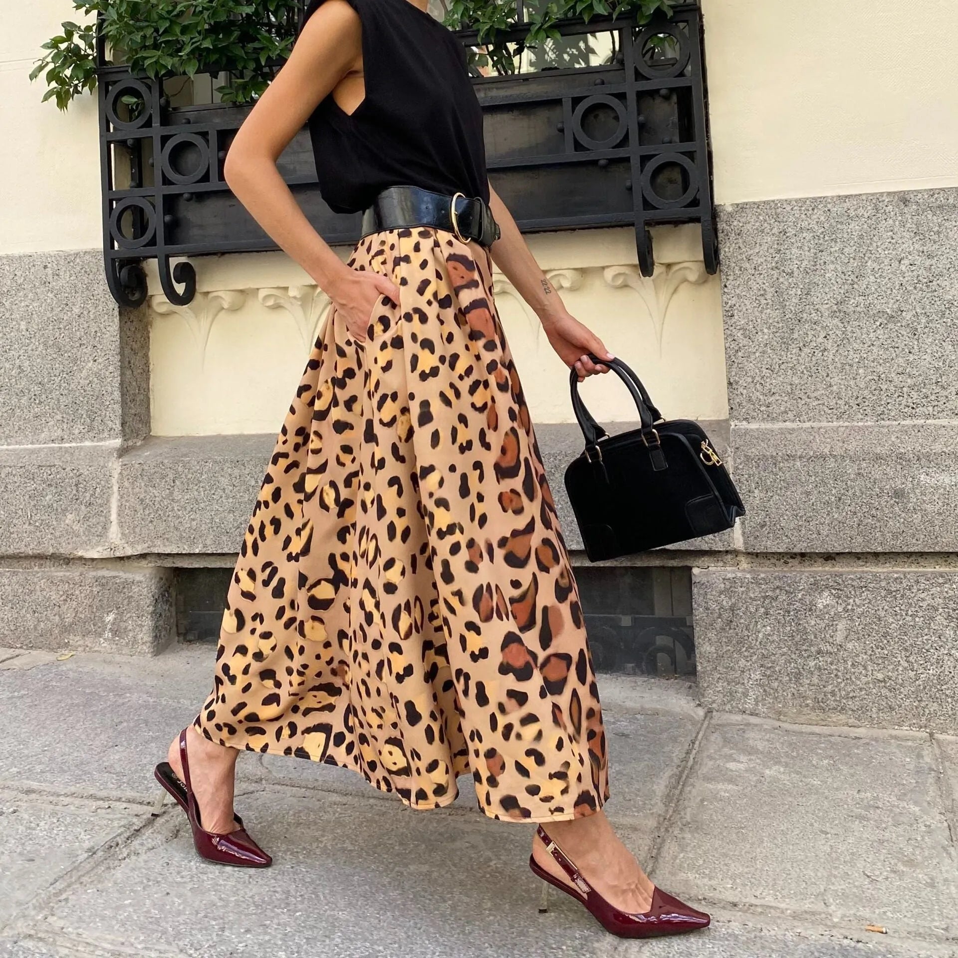 Brown leopard print women's A-line long skirt with a deep, flowing hem on a hanger.