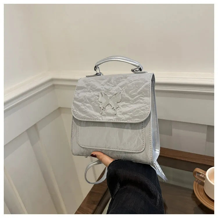 Women's white PU leather hand-carry backpack with bow detail and mobile phone compartment