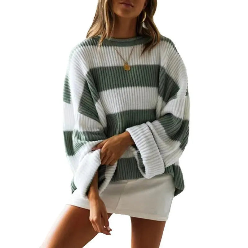 Woman wearing a loose striped sweater with long bell sleeves and white crocheted flower details on the front.