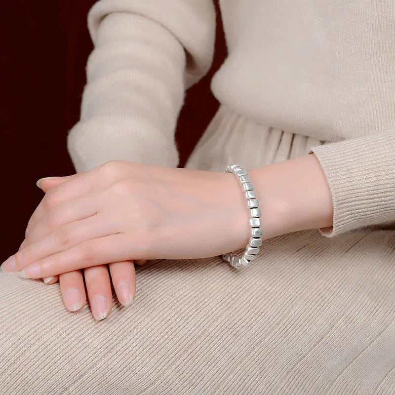 Handmade women's bracelet with irregular silver square and wood on a black elastic band.