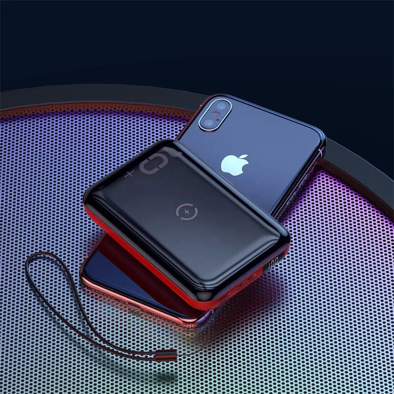 Small square black portable power bank with LED digital display on a table.