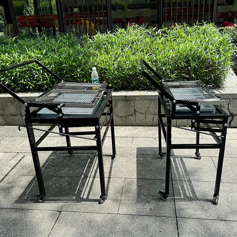 Large black stainless steel portable charcoal barbecue grill in a foldable design.