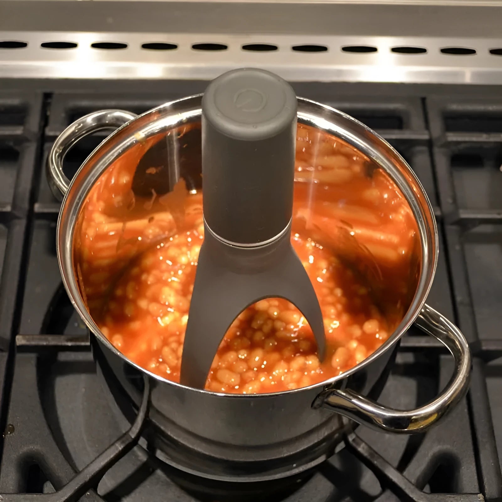 Green and grey automatic cooking mixer device for stirring sauces and soups.